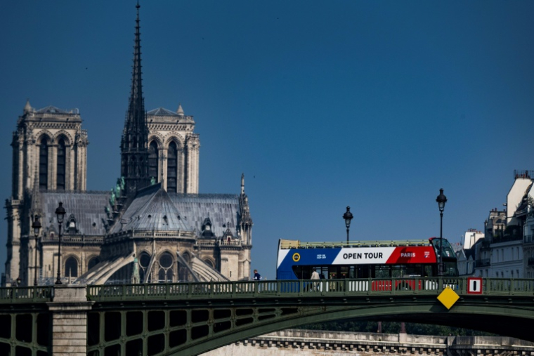 Un bus touristique passe derrière la cathédrale Notre-Dame de Paris, le 20 mai 2018 ( AFP / Lionel BONAVENTURE )