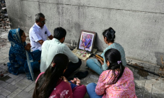 Des proches de victimes du crash du vol Air India 171, survenu l'année dernière, lors d'un hommage aux disparus sur le site de l'accident à Ahmedabad, le 11 juin 2026 ( AFP / Shammi MEHRA )