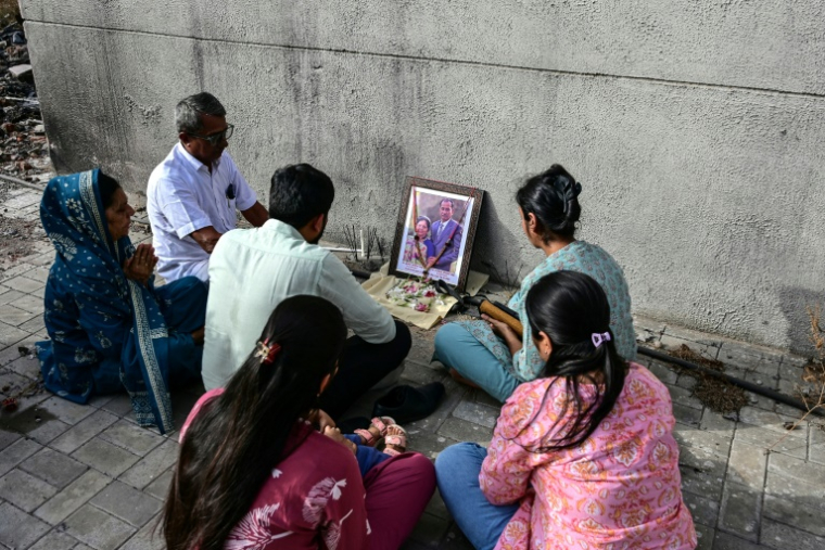 Des proches de victimes du crash du vol Air India 171, survenu l'année dernière, lors d'un hommage aux disparus sur le site de l'accident à Ahmedabad, le 11 juin 2026 ( AFP / Shammi MEHRA )