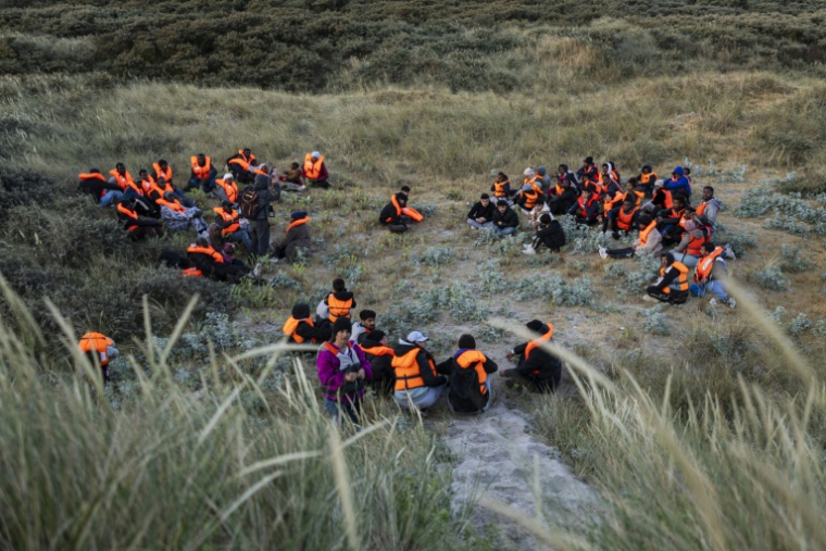 Des migrants, cachés dans les dunes, attendent le bateau d'un passeur et tenter de traverser la Manche au large de la plage de Gravelines, le 16 juin 2025 dans le Nord ( AFP / Sameer Al-DOUMY )