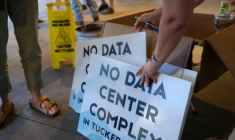 Des bénévoles distribuent des pancartes anti-data center en marge d'une réunion publique à Canaan Valley, en Virginie occidentale, le 30 juin 2025 ( AFP / Ulysse BELLIER )