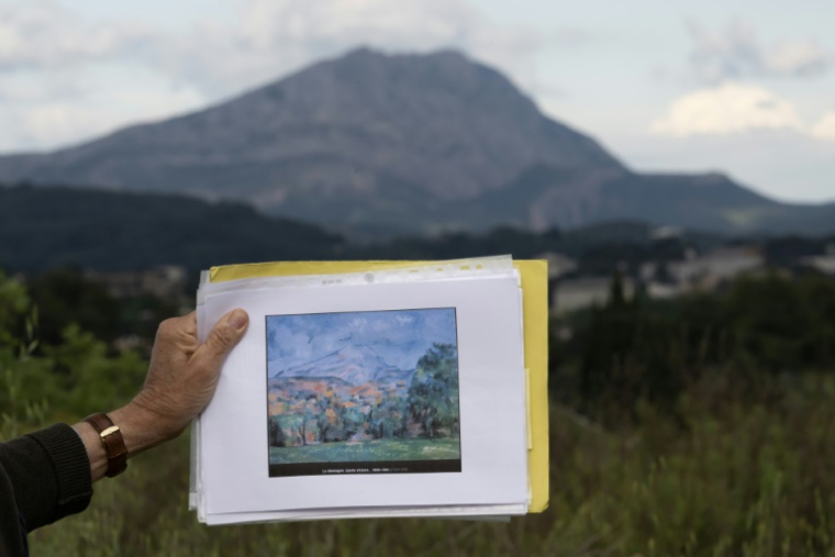 Une reproduction de l'œuvre du peintre Paul Cézanne intitulée "Montagne Sainte-Victoire", avec la montagne Sainte-Victoire en arrière-plan à Aix-en-Provence, le 6 mai 2025 ( AFP / MIGUEL MEDINA )