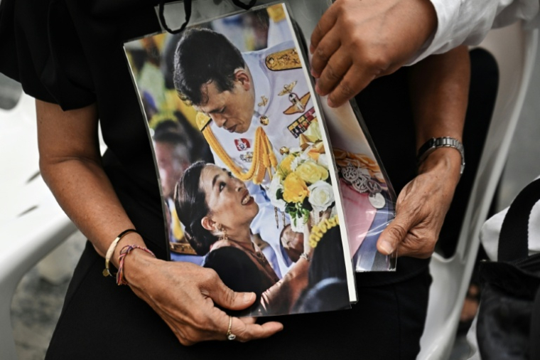 Des personnes rassemblées pour rendre hommage à la princesse Bajrakitiyabha Mahidol décédée tiennent une photo d'elle et de son père le roi thaïlandais Maha Vajiralongkorn dans l'hôpital Chulalongkorn de Bangkok le 12 juin 2026, en Thaïlande ( AFP / Lillian SUWANRUMPHA )