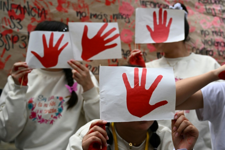 Des enfants participent à une manifestation lors de la Journée internationale contre l'utilisation d'enfants soldats, également connue sous le nom de "Journée de la main rouge", sur la place Bolivar à Bogota le 12 février 2025 en Colombie ( AFP / Raul ARBOLEDA )