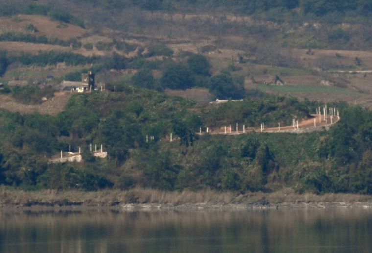 Un poste de garde nord-coréen et des clôtures militaires, du côté nord de la zone démilitarisée (DMZ) séparant les deux Corées, visibles depuis Paju, le 20 octobre 2026 en Corée du Sud ( AFP / Jung Yeon-je )
