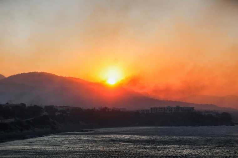 Lever de soleil dans la fumée des incendies près de Ierapetra sur l'île grecque de Crète, le 3 juillet 20252025. ( AFP / Costas Metaxakis )