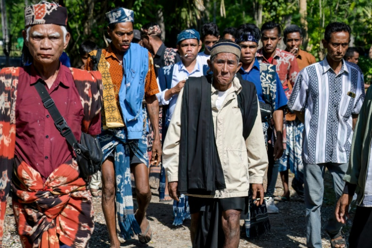 Des personnes en deuil, habillées de vêtements traditionnels, assistent aux  funérailles d'un noble sur l'île de Sumba, le 26 juin 2026 en Indonésie ( AFP / BAY ISMOYO )