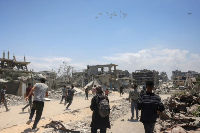 Des Palestiniens se précipitent pour recueillir de l'aide humanitaire qu'un avion vient de larguer à Jabalia, dans le nord de la bande de Gaza, le 1er août 2025 ( AFP / Bashar TALEB )