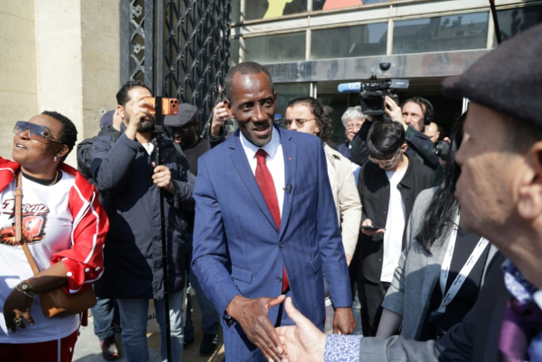 Le maire LFI de Saint-Denis, Bally Bagayoko (c), salue des partisans à l'issue de la première séance du nouveau conseil municipal de Saint-Denis, le 21 mars 2026 en Seine-Saint-Denis ( AFP / Ludovic MARIN )