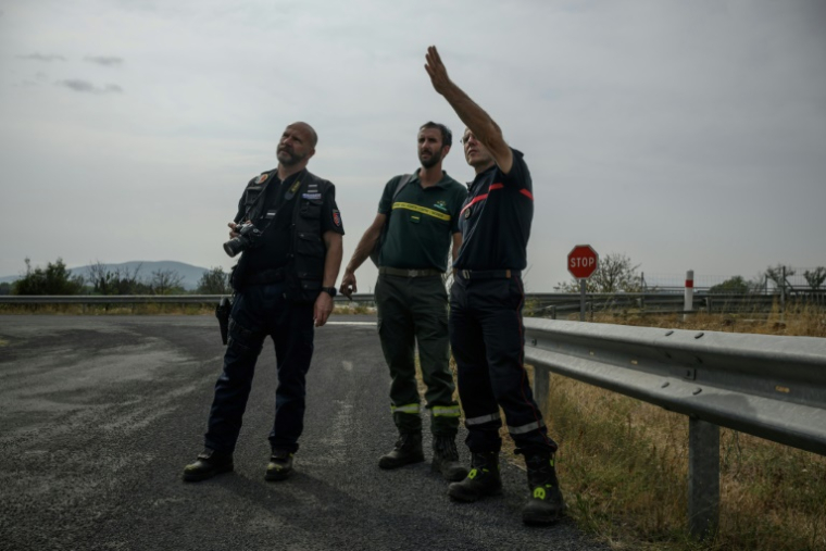(g-d) Le gendarmer Emmanuel Guinard, Stéphane Paoli, technicien de l'ONF et Jean-Paul Baylac, chef du service des incendies de forêt du Service d'incendie et de secours de l'Aude, inspectent une zone touchée par un récent incendie de forêt, à Luc-sur-Orbieu, près de Narbonne, le 19 août 2025 ( AFP / Ed JONES )