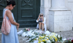 Une femme assise pleure le 5 septembre 2025 près du site où un funiculaire a déraillé à Lisbonne faisant 16 morts ( AFP / PATRICIA DE MELO MOREIRA )