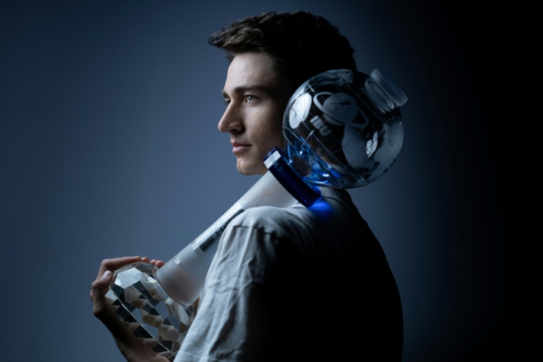 Eric Perrot tient son gros globe de cristal de vainqueur de la Coupe du monde de biathlon, le 25 mars 2026 a Paris ( AFP / Joel Saget )