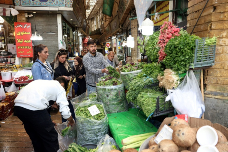 Des Iraniens font leurs courses de fruits et légumes sur un marché du nord de Téhéran, le 21 avril 2026 ( AFP / - )