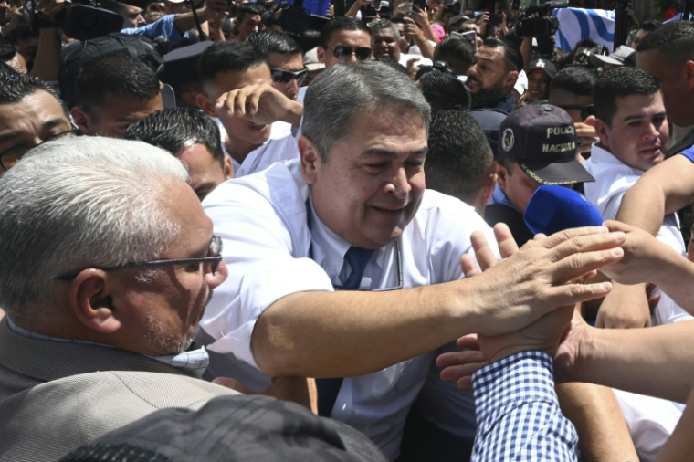 L'ex-président du Honduras, Juan Orlando Hernandez, salue ses partisans après une audience à la Cour suprême de justice à Tegucigalpa, le 3 août 2026 ( AFP / Orlando SIERRA )