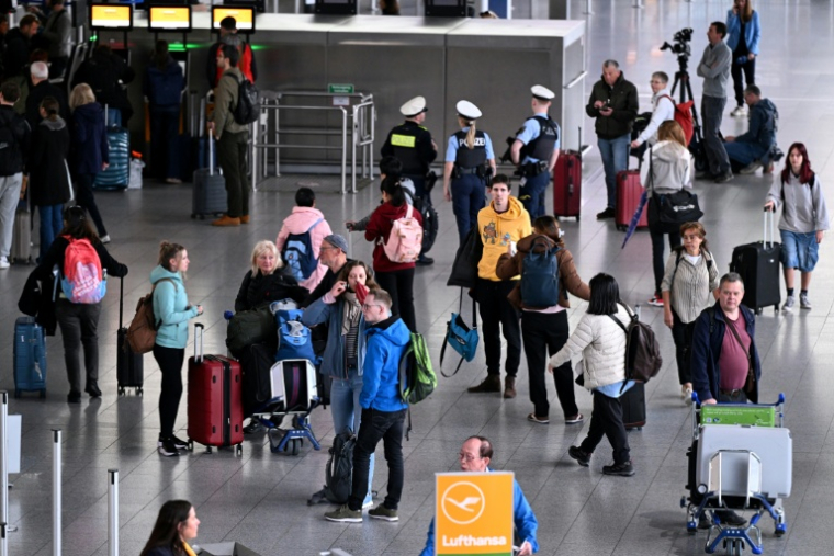 Des passagers attendent près d'un comptoir de la compagnie aérienne à l'aéroport de Francfort, alors qu'une grande partie des vols sont annulés pour cause de grève le 12 mars 2026 ( AFP / Kirill KUDRYAVTSEV )