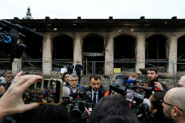Le maire de Lyon, Grégory Doucet, s'adresse à la presse devant l'Office du tourisme incendié la veille lors d'une manifestation contre la vie chère, le 18 octobre 2026 ( AFP / Jeff PACHOUD )