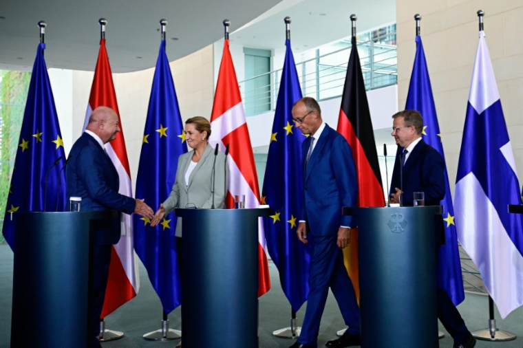 De gauche à droite : le chancelier autrichien Christian Stocker serre la main de la Première ministre danoise Mette Frederiksen, le chancelier allemand Friedrich Merz et le Premier ministre finlandais Petteri Orpo lors d'une conférence de presse à Berlin le 27 août 2026 ( AFP / Tobias SCHWARZ )