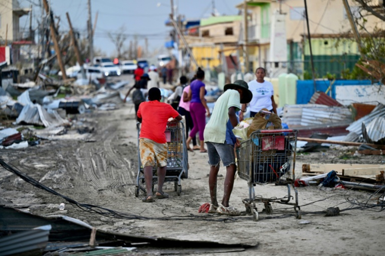 Des habitants de Black River, en Jamaïque, récupèrent de la nourriture après le passage de l'ouragan Melissa, le 29 octobre 2025 ( AFP / Ricardo MAKYN )