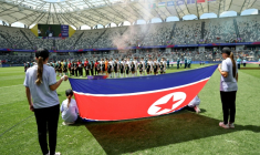 Les joueuses du Bangladesh et de la Corée du Nord derrière le drapeau national nord-coréen avant le coup d'envoi du match de la Coupe d'Asie féminine de l'AFC 2026 en Australie opposant le Bangladesh à la Corée du Nord, à Sydney, le 6 mars 2026 ( AFP / DAVID GRAY )