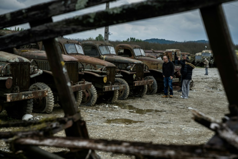 Des visiteurs se promènent parmi des épaves de véhicules militaires de la Seconde Guerre mondiale exposées à La Sône, le 8 mai 2025 en Isère ( AFP / JEAN-PHILIPPE KSIAZEK )