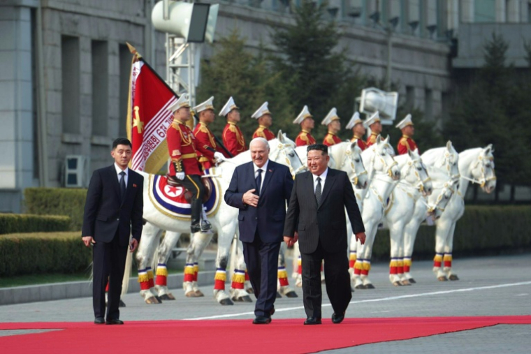 Photo fournie par le service de presse présidentiel bélarusse du dirigeant nord-coréen Kim Jong-un, à droite, et du président bélarusse Alexandre Loukachenko, au cente à gauche, à Pyongyang en Corée du Nord le 25 mars 2026 ( Belarusian presidential press service / Handout )
