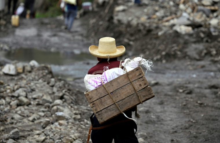 Un habitant de San Bartolo Tutotepec, dans l'Etat mexicain d'Hidalgo, contourne un glissement de terrain, le 13 octobre 2025 ( AFP / Alfredo ESTRELLA )