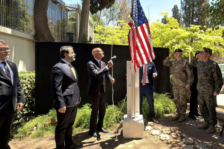 L'envoyé spécial américain pour la Syrie et ambassadeur en Turquie, Thomas Barrack (c), aux côtés du ministre syrien des Affaires étrangères Assaad al-Chaibani (2e g), hisse le drapeau des États-Unis à la résidence de l'ambassadeur américain à Damas, lors d'une cérémonie officielle le 29 mai 2025 ( AFP / Rami al SAYED )