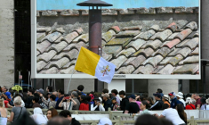 Des fidèles à Rome scrutent sur un écran la cheminée de la chapelle Sixtine au deuxième jour du conclave le 8 mai 2025 ( AFP / Andreas SOLARO )