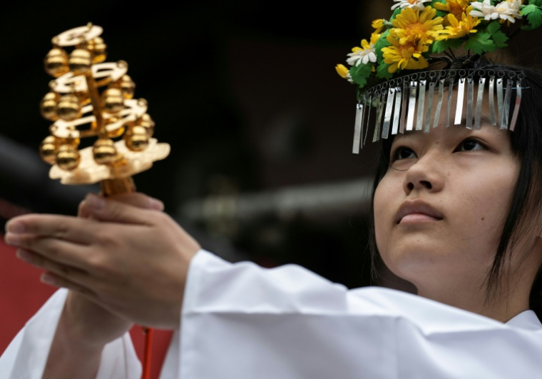 Une femme dirige une cérémonie avant le départ d'une procession lors du festival Kanamara à Kawasaki, près de Tokyo, le 5 avril 2026 ( AFP / Andrew CABALLERO-REYNOLDS )