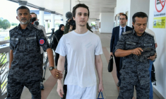 Le Français Tom Felix (c) accompagné par des agents de l'immigration après avoir été acquitté de huit chefs d'accusation liés à la drogue devant la Haute Cour d'Alor Setar, le 3 février 2026 en Malaisie ( AFP / Hakim Mustapha )