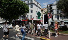 Des piétons dans une rue de Cannes où les feux tricolorent ne fonctionnent pas en raison d'une panne de courant, au dernier jour du 78e Festival de Cannes, le 24 mai 2025 dans les Alpes-Maritimes ( AFP / Sameer AL-DOUMY )