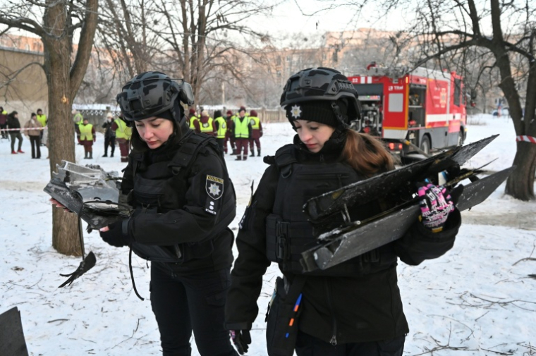 Des policières ukrainiennes ramassent des débris de drones après une attaque russe à Kharkiv, le 3 février 2026 ( AFP / SERGEY BOBOK )