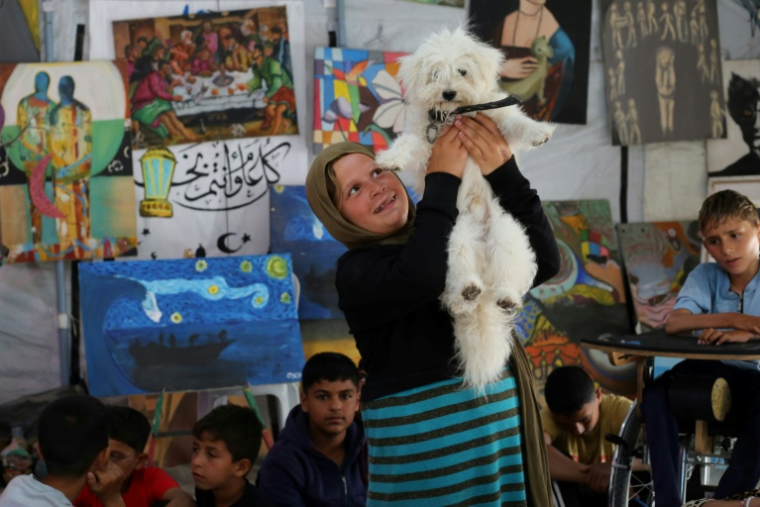 Displaced Palestinian children participate in psychological debriefing sessions at an art studio that uses pets and birds to aid the children, in the Al-Zawaida area, in the central Gaza Strip on April 21, 2026. ( AFP / Eyad Baba )