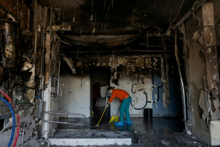Une femme dégage des débris après l'attaque par des drones d'une clinique privée à Kiev, le 5 janvier 2026, en Ukraine ( AFP / Tetiana DZHAFAROVA )