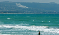 Une personne prend un bain de mer face au village d'El Mansouri, dans le sud du Liban, pendant un bombardement israélien le 22 mai 2026 ( AFP / KAWANT HAJU )