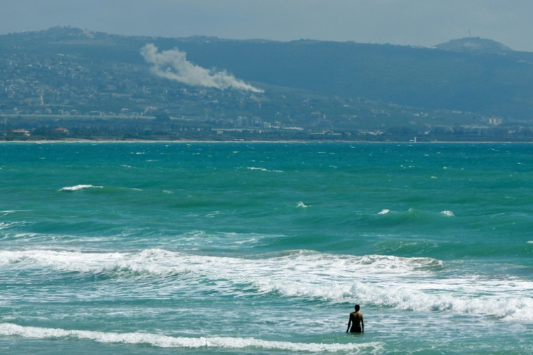 Une personne prend un bain de mer face au village d'El Mansouri, dans le sud du Liban, pendant un bombardement israélien le 22 mai 2026 ( AFP / KAWANT HAJU )