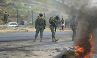 Des militaires montent la garde sur l'autoroute panaméricaine Nord, où des habitants ont bloqué la route lors d'une manifestation contre la fin des subventions au diesel dans la commune de San Miguel del Comun, près de Quito, le 16 septembre 2025 en Equateur ( AFP / Rodrigo BUENDIA )