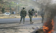 Des militaires montent la garde sur l'autoroute panaméricaine Nord, où des habitants ont bloqué la route lors d'une manifestation contre la fin des subventions au diesel dans la commune de San Miguel del Comun, près de Quito, le 16 septembre 2025 en Equateur ( AFP / Rodrigo BUENDIA )