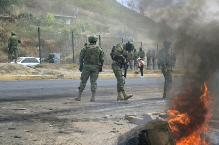 Des militaires montent la garde sur l'autoroute panaméricaine Nord, où des habitants ont bloqué la route lors d'une manifestation contre la fin des subventions au diesel dans la commune de San Miguel del Comun, près de Quito, le 16 septembre 2025 en Equateur ( AFP / Rodrigo BUENDIA )
