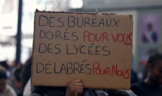 Un élève tient une pancarte lors d'un blocage devant le lycée Paul-Éluard