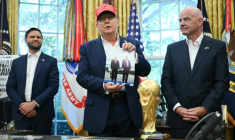 Le président américain Donald Trump, entouré du vice-président JD Vance et du chef de la FIFA Gianni Infantino, montre une photo sur laquelle il figure en compagnie de son homologue russe Vladimir Poutine, le 22 août 2025 à la Maison Blanche ( AFP / ANDREW CABALLERO-REYNOLDS )