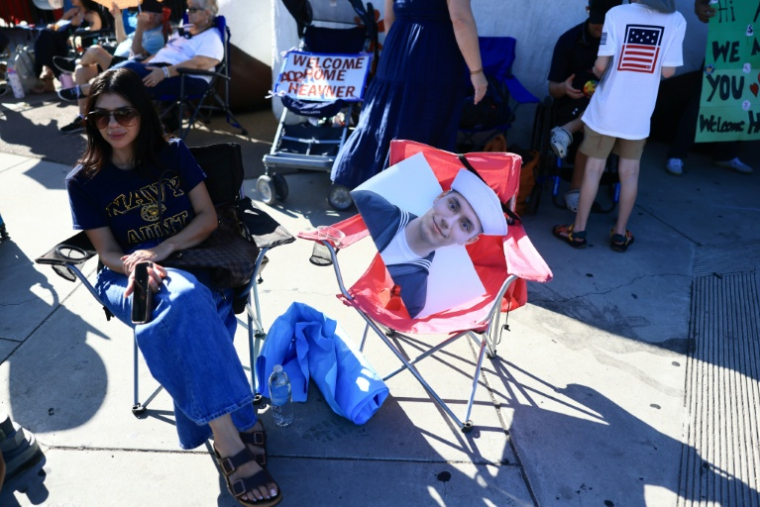 Une femme attend un membre de sa famille, militaire embarqué à bord du porte-avions USS Abraham Lincoln, dans le port de San Diego, en Californie, le 8 octobre 2026 ( AFP / David Swanson )