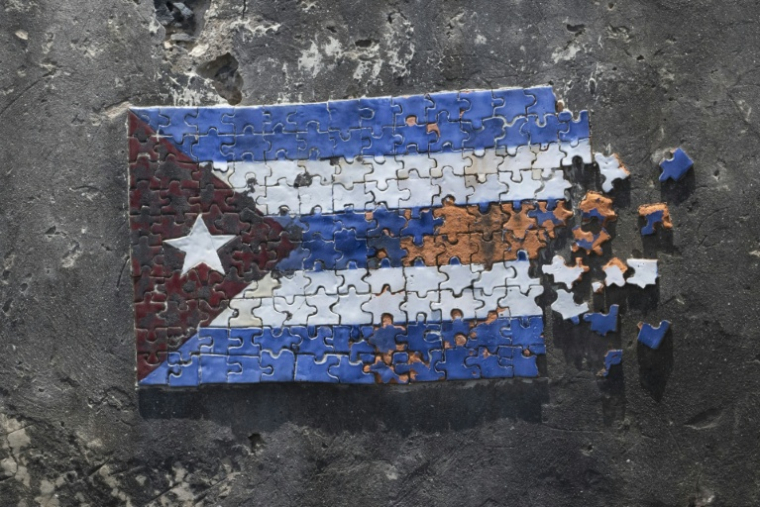 Une mosaïque représentant le drapeau cubain sous la forme d'un puzzle apparaît sur une section d'un mur de fortification côtière le long du front de mer à La Havane, le 18 juin 2026 ( AFP / Pablo PORCIUNCULA )