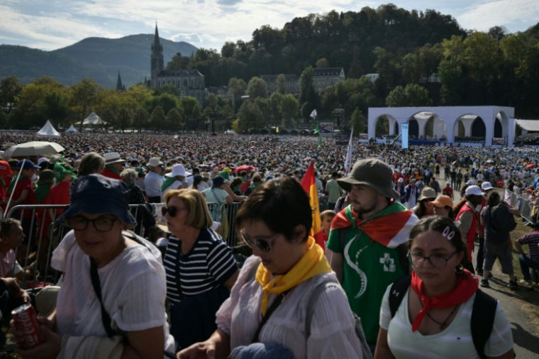 Des fidèles rassemblés sur la prairie du sanctuaire marial de Lourdes, lors de la messe célébrée par le pape Léon XIV, le 27 septembre 2026 ( AFP / Ed JONES )