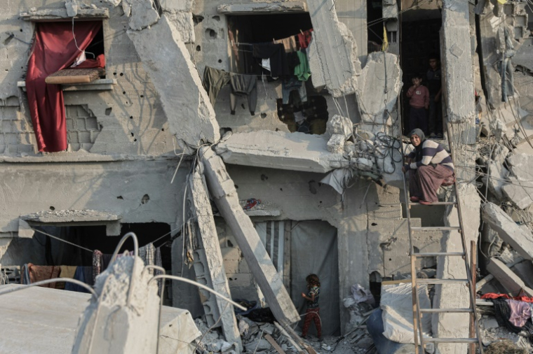 Une femme sur une échelle devant sa maison lourdement endommagée, à Jabalia, dans la bande de Gaza, le 7 novembre 2025 ( AFP / Omar AL-QATTAA )
