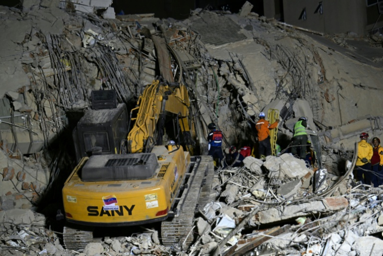 Des équipes de secours utilisent des engins de chantier sur le site d'un immeuble effondré à Caracas, le 25 juin 2026, à la suite de séismes ( AFP / Juan BARRETO )