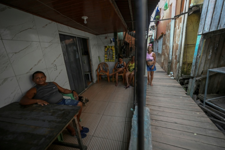 Des habitants de Vila da Barca, un quartier pauvre bâti sur pilotis sur les rives du fleuve Guama à Belem, dans l'État du Para, le 5 novembre 2025 au Brésil ( AFP / Mauro PIMENTEL )