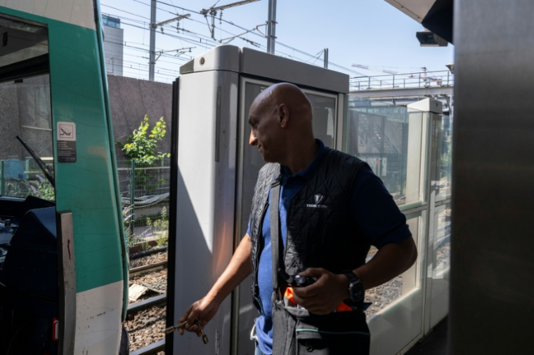 Un conducteur de metro de la RATP à Paris, portant un gilet rafraichissant pour entrer dans la cabine de pilotage de la ligne 13 du métro à Chatillon, le 12 aout 2025 ( AFP / Martin LELIEVRE )