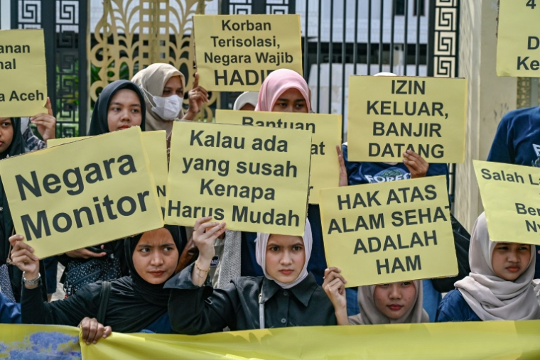 Des militants brandissent des pancartes lors d'une manifestation pour réclamer une aide humanitaire pour les victimes des inondations dans les provinces d'Aceh, de Sumatra Nord et de Sumatra Ouest, devant le Conseil représentatif du peuple d'Aceh (DPRA) à Banda Aceh, le 16 décembre 2025 ( AFP / CHAIDEER MAHYUDDIN )