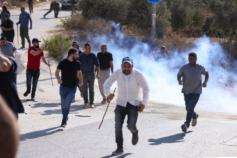 Des Palestiniens courent se mettre à couvert après une attaque présumée de colons et de soldats israéliens pendant la récolte des olives dans le village de Beitan au sud de Naplouse, en Cisjordanie occupée, le 2 octobre 2026 ( AFP / JAAFAR ASHTIYEH )